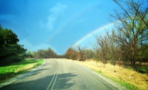 What I like about this picture is how the road curves to the left, while the rainbow veers off to the right. If you look closely you can see not only a faint double rainbow but tire tracks that appear to be following the rainbow.